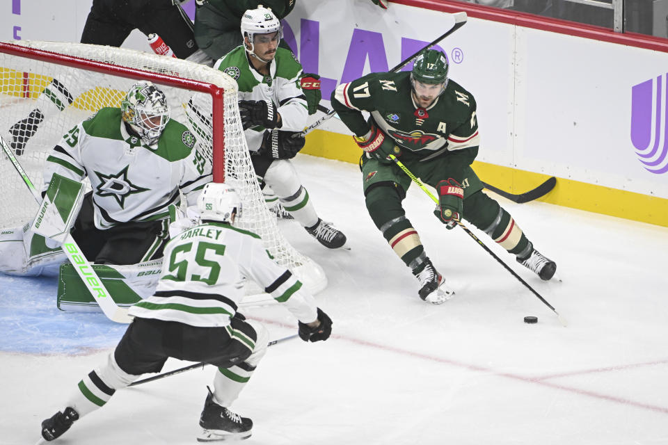 Minnesota Wild left wing Marcus Foligno (17) skates past Dallas Stars goalie Jake Oettinger, left, as Stars defenseman Thomas Harley (55) and left wing Mason Marchment, center top, defend during the first period of an NHL hockey game Sunday, Nov. 12, 2023, in St. Paul, Minn. The Stars won 8-3. (AP Photo/Craig Lassig)