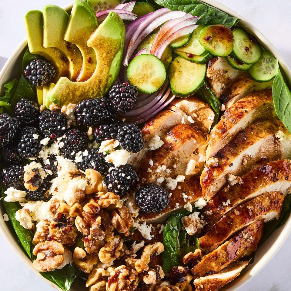 salad with sliced chicken, blackberries, sliced cucumber, red onion, and walnuts