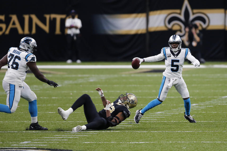 Carolina Panthers quarterback Teddy Bridgewater (5) scrambles past New Orleans Saints defensive end Marcus Davenport as offensive tackle Russell Okung (76) blocks in the first half of an NFL football game in New Orleans, Sunday, Oct. 25, 2020. (AP Photo/Brett Duke)