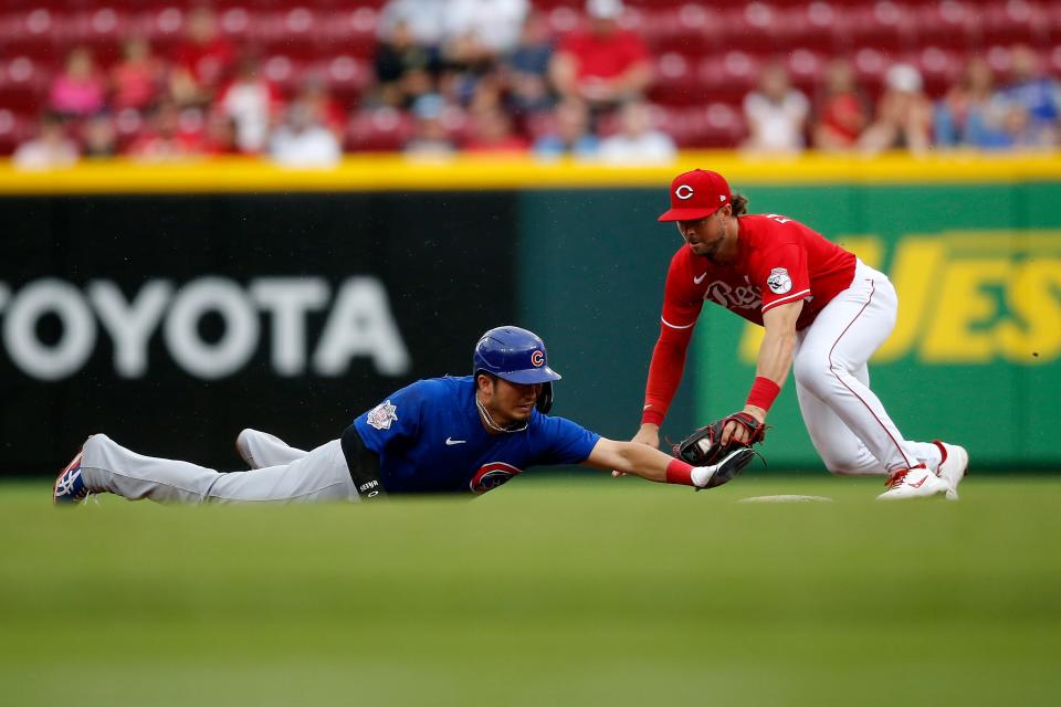 Chicago Cubs right fielder Seiya Suzuki (27) dives back to the bag after over sliding attempting to steal second and is tagged out by Cincinnati Reds shortstop Kyle Farmer (17) in the third inning of the MLB National League game between the Cincinnati Reds and the Chicago Cubs at Great American Ball Park in downtown Cincinnati on Thursday, May 26, 2022. The Reds led 10-3 after three innings. 