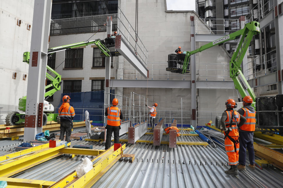 Construction workers lift a Steele beam into position at the 8 Bishopsgate development in London, Thursday, April 1, 2021. When the pandemic struck, about 540,000 workers vanished from London's financial hub almost overnight. Developers of 8 Bishopsgate, are confident that when construction ends late next year, workers and firms will return to fill all 50 floors of the gleaming new office space. (AP Photo/Alastair Grant)