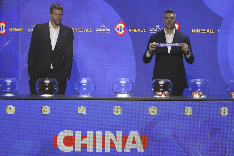 FIBA ambassador and former NBA star Luis Scola, right, shows the ticket for China national basketball team beside German former NBA basketball player Dirk Nowitzki during the FIBA World Cup 2023 draw in Quezon city, Philippines on Saturday April 29, 2023. (AP Photo/Josefino de Guzman)