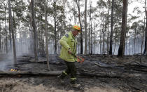 Forestry Corportaion worker Dale McLean patrols a controlled fire as they work at building a containment line at a wildfire near Bodalla, Australia, Sunday, Jan. 12, 2020. Authorities are using relatively benign conditions forecast in southeast Australia for a week or more to consolidate containment lines around scores of fires that are likely to burn for weeks without heavy rainfall. (AP Photo/Rick Rycroft)