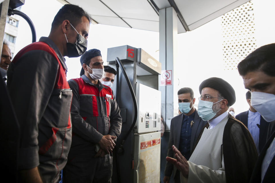 In this photo released by the official website of the office of the Iranian Presidency, President Ebrahim Raisi, second right, speaks with gas station workers in Tehran, Iran, Wednesday, Oct. 27, 2021. Raisi said Wednesday that a cyberattack which paralyzed every gas station in the Islamic Republic was designed to get "people angry by creating disorder and disruption," as long lines still snaked around the pumps a day after the incident began. (Iranian Presidency Office via AP)