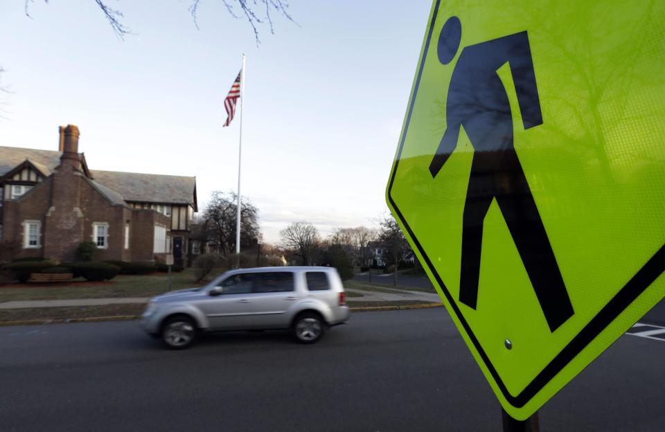 In this Dec. 27, 2013, photo a vehicle drives in front of Forest Avenue Elementary School in Glen Ridge, N.J. A presidential commission appointed by President Barack Obama is grappling with concerns that some schools no longer want to serve as polling places amid security concerns since the shooting in Newtown, Conn. Among those schools that have closed to balloting is Forest Avenue Elementary School. (AP Photo/Julio Cortez)