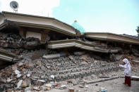 <p>A girl stand next to the collapsed mosque after an earthquake hit on Sunday in North Lombok, Indonesia on Friday, Aug. 7, 2018.<br>(Photo: Garry Lotulung/NurPhoto via Getty Images) </p>