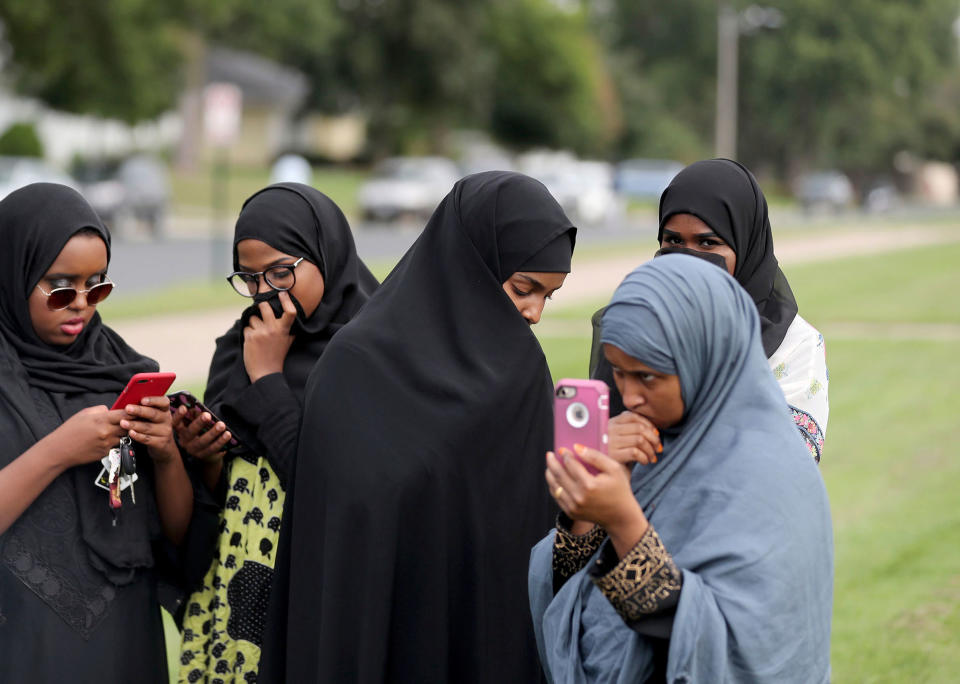 <p>People make phone calls as law enforcement investigate an explosion at the Dar Al-Farooq Islamic Center in Bloomington, Minn., on Saturday, Aug. 5, 2017. (Photo: David Joles/Star Tribune via AP) </p>