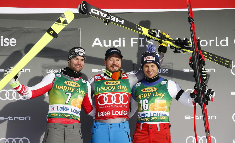 Kjetil Jansrud, center, of Norway, celebrates his victory with second place finisher Vincent Kriechmayr, left, of Austria, and third place finisher Mauro Caviezel, of Switzerland, in the men's World Cup super-G ski race at Lake Louise, Alberta, Sunday, Nov. 25, 2018. (Jeff McIntosh/The Canadian Press via AP)