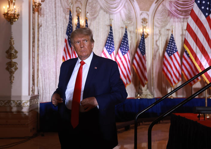 Looking disgruntled, former U.S. President Donald Trump leaves the stage, with a bank of U.S. flags in the background.