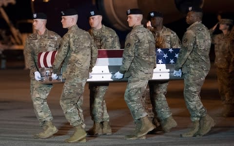 An Army carry team moves a transfer case containing the remains of Sgt. 1st Class Elis Barreto Ortiz - Credit: &nbsp;Cliff Owen/AP