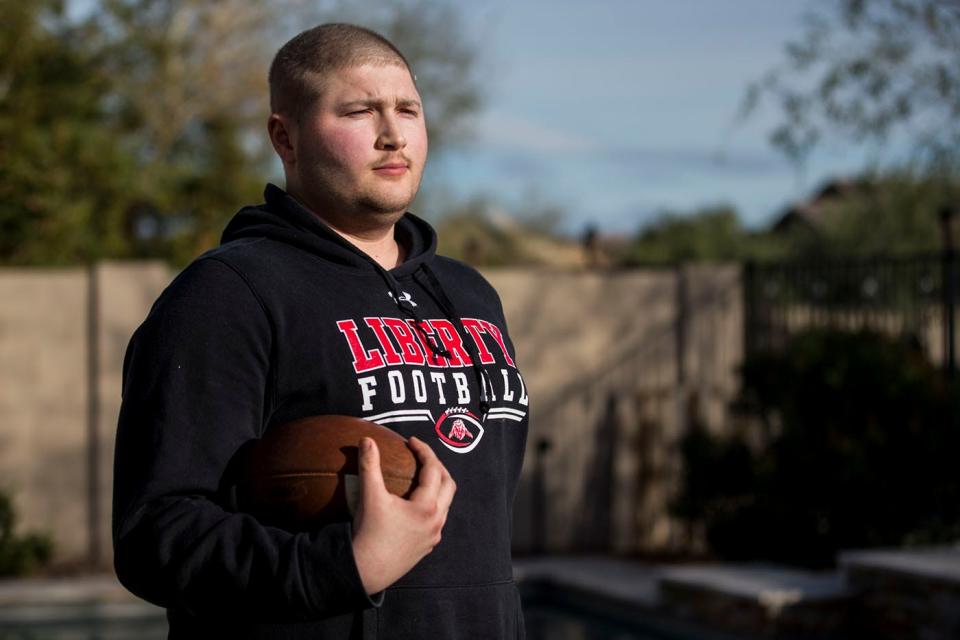 Zach Hunzinger poses for a portrait on Monday, Feb. 4, 2019, at his home in Peoria, Ariz. Hunzinger, an offensive lineman for Liberty High School, was diagnosed with bone cancer but has since been told that he is cancer-free.