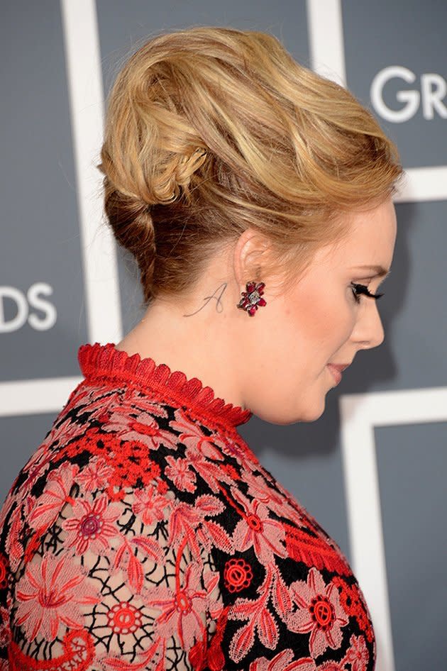 <p>Adele may have kept the dress subdued but she did reveal something new at the Grammys. Check out the tattoo "A" behind her right ear. Word has it the tattoo represents her son, who is rumoured to have been named Angelo. Either that or it stands for her own name, Adele.</p>