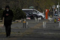 A man walks by policemen monitoring inside a police vehicle parked near the site of last weekend protest in Beijing, Tuesday, Nov. 29, 2022. With police out in force, there was no word of protests Tuesday in Beijing, Shanghai or other major cities. (AP Photo/Andy Wong)