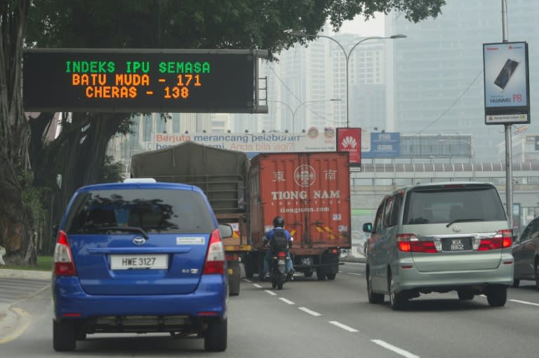 Motorists drive past a digital board displaying the latest air pollutant index as haze shrouds Kuala Lumpur, Malaysia, on September 15, 2015