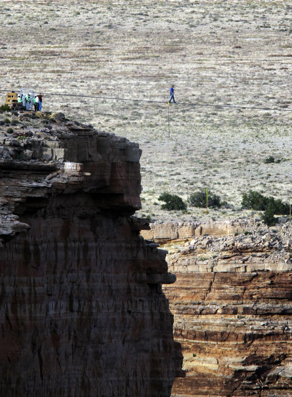 FILE - In this June 23, 2013, file photo, daredevil Nik Wallenda crosses a tightrope 1,500 feet above the Little Colorado River Gorge, Ariz., on the Navajo Nation outside the boundaries of Grand Canyon National Park. When actor Will Smith turns 50 on Tuesday, Sept. 25, 2018, he will jump head-first into the big milestone. The “Fresh Prince” plans to bungee jump from a helicopter over a gorge just outside Grand Canyon National Park. His birthday activity is the latest in a vast history of outrageous stunts staged in and around one of the world’s seven natural wonders. (AP Photo/Rick Bowmer, File)
