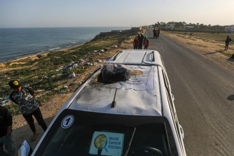 Palestinians inspect a vehicle with the logo of the World Central Kitchen wrecked by an Israeli airstrike in Deir al Balah, Gaza Strip, Tuesday, 2 April  2024 (AP)