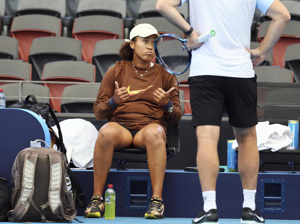 Naomi Osaka of Japan talks with her coach during a training session ahead of the Brisbane International tennis tournament in Brisbane, Australia, Wednesday, Dec. 27, 2023. (AP Photo/Tertius Pickard)