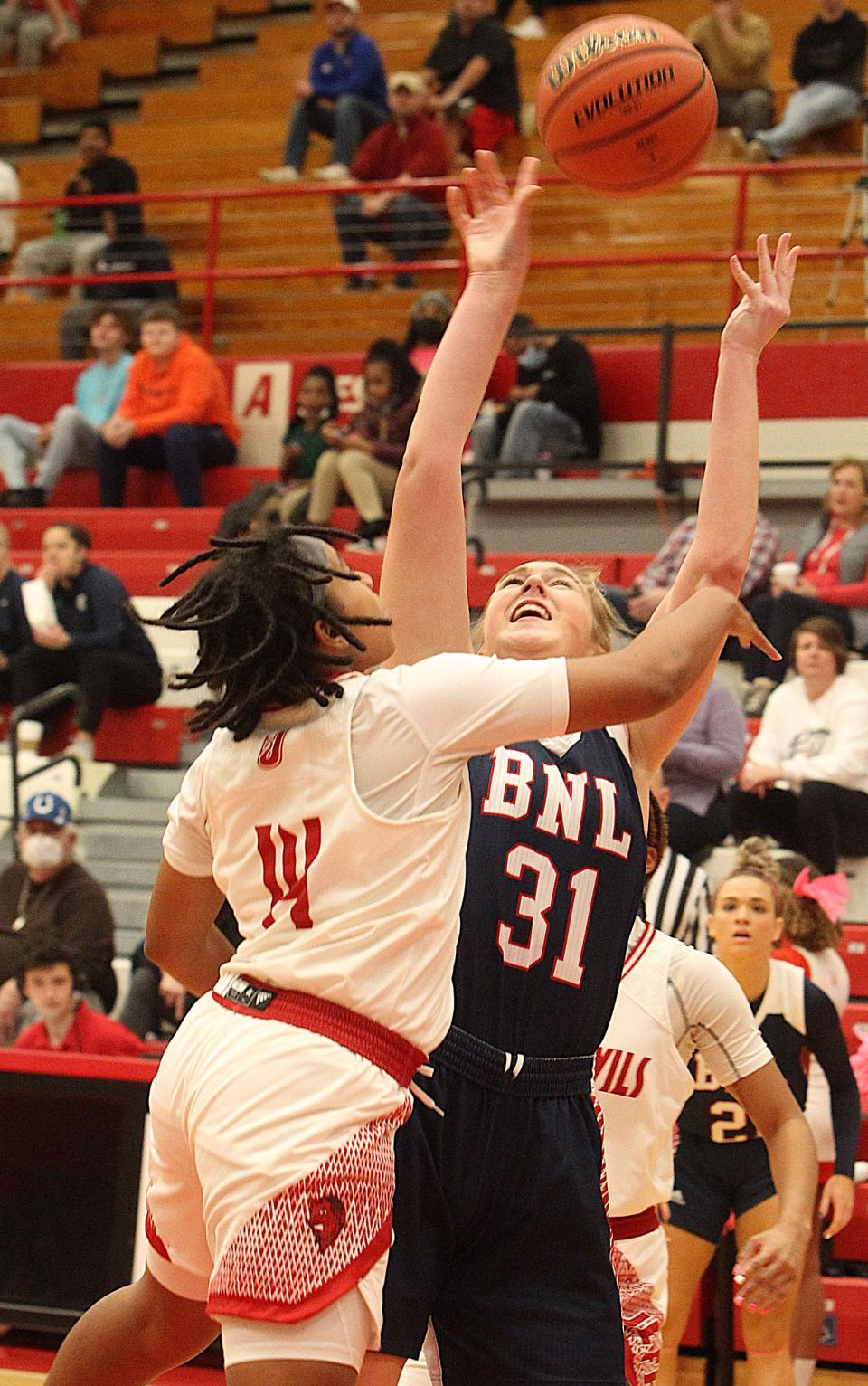 Bedford North Lawrence's Ella Turner (31) is fouled on the shot by a Jeffersonville defender during sectional action.