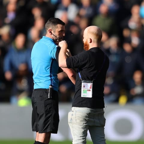 Referee Michael Oliver receives some technical support during the Premier League match between Watford FC and Tottenham Hotspur - Credit: GETTY IMAGES