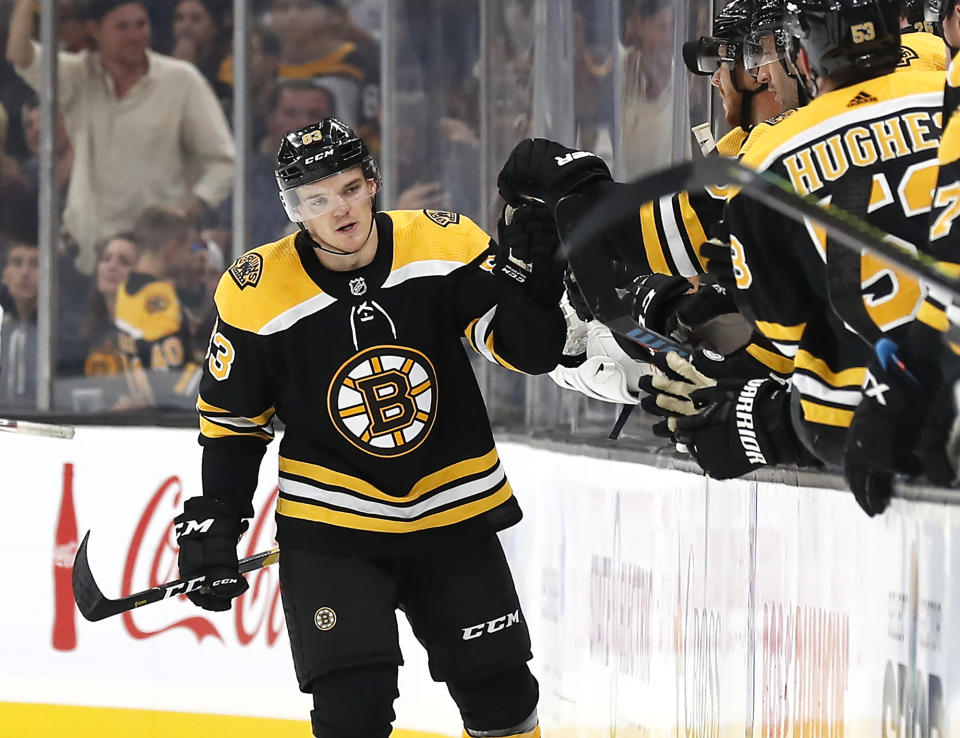 Boston Bruins' Karson Kuhlman is congratulated at the bench after scoring against the Chicago Blackhawks during the second period of an NHL preseason hockey game Saturday, Sept. 28, 2019, in Boston. (AP Photo/Winslow Townson)