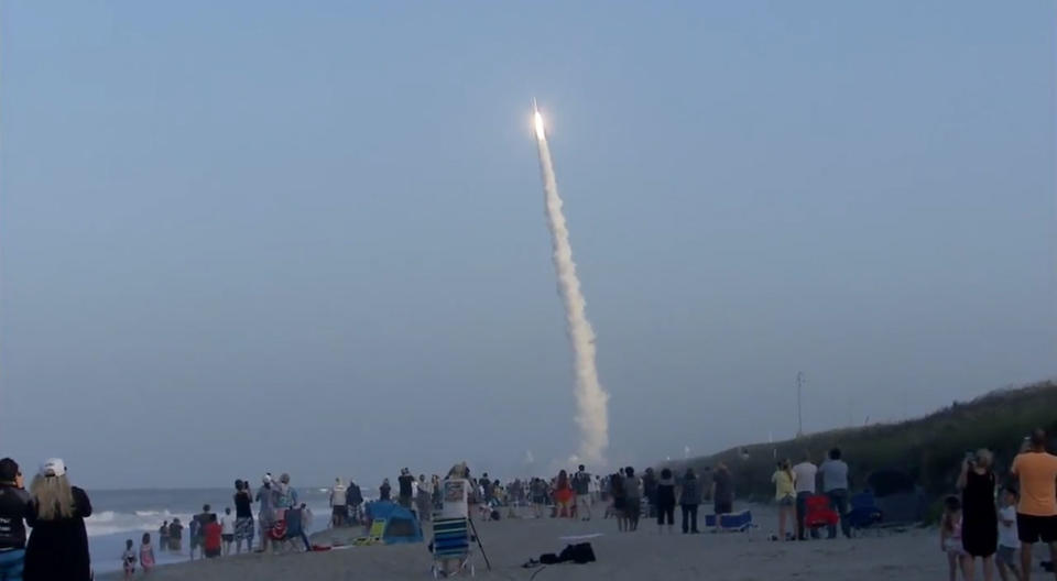 Beach-goers watch a United Launch Alliance Atlas V rocket launch into space carrying two military satellites on the AFSPC-11 mission. Liftoff occurred at 7:13 p.m. EDT on April 14, 2018. <cite>United Launch Alliance</cite>
