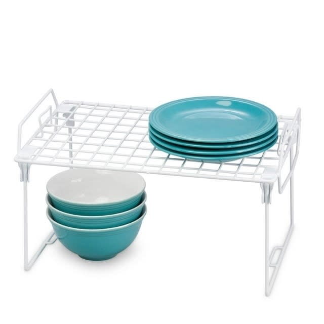 the wire shelf organizer with plates on it and bowls under it