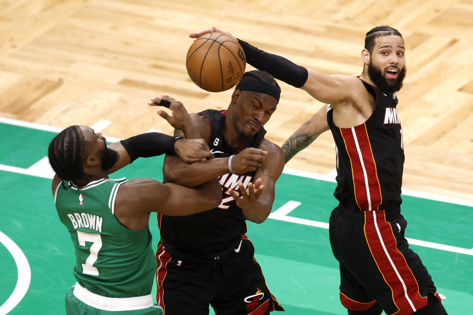 Boston Celtics guard Jaylen Brown, left, and Miami Heat forward Jimmy Butler, center, grapple for the ball along with forward Caleb Martin during the first half in Game 7 of the NBA basketball Eastern Conference finals Monday, May 29, 2023, in Boston. (AP Photo/Michael Dwyer)