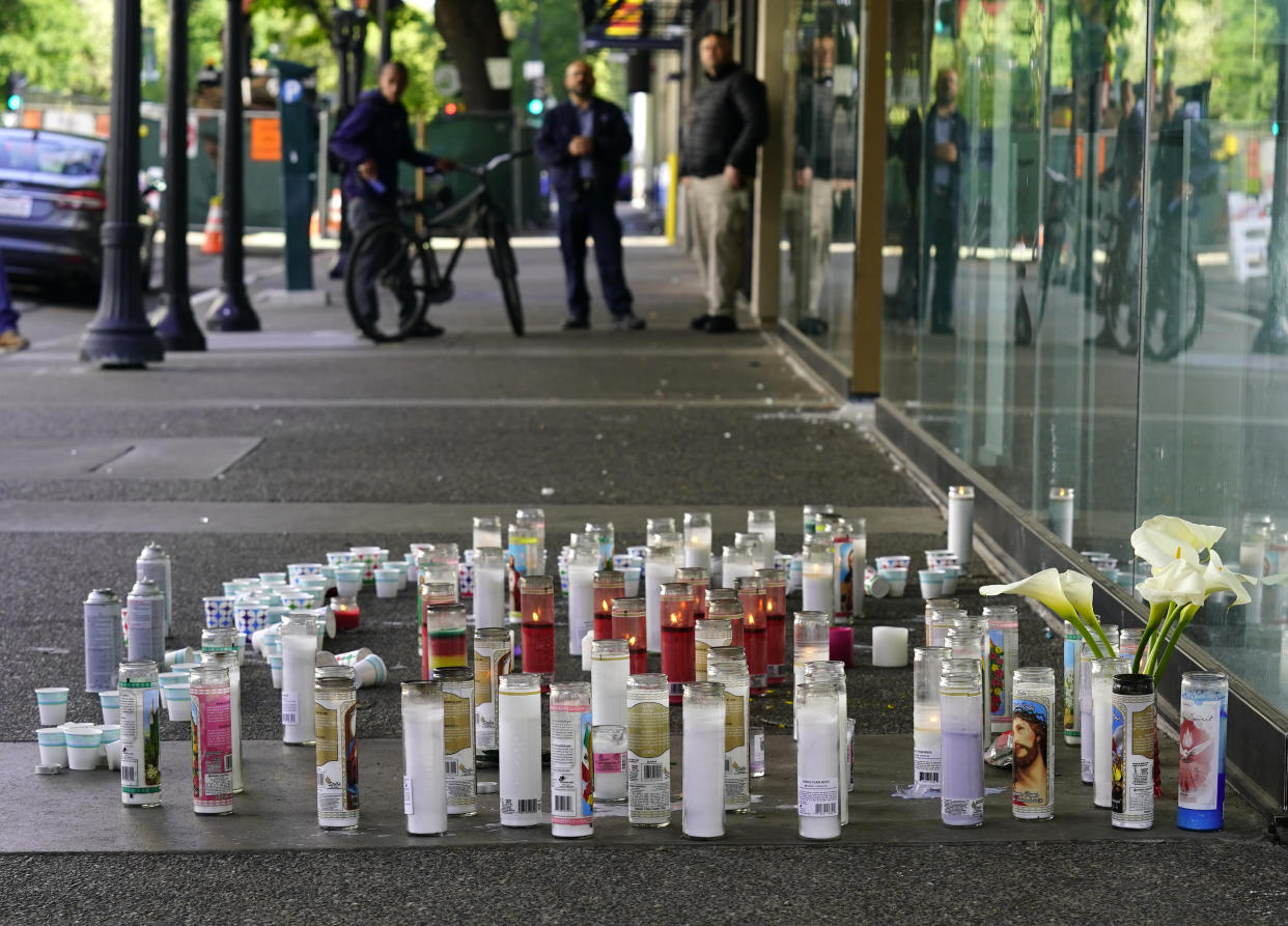 FILE - Candles and flowers make up a memorial on April 5, 2022, at a memorial for those killed and injured in a mass shooting in Sacramento, Calif. A suspect in the mass shooting that rocked California's capital city earlier this month is scheduled to appear in court, Friday, April 22, 2022. Smiley Martin was allegedly part of a gang shootout in downtown Sacramento that killed six people and wounded a dozen more, including Martin and his brother, who was also arrested. (AP Photo/Rich Pedroncelli, File)