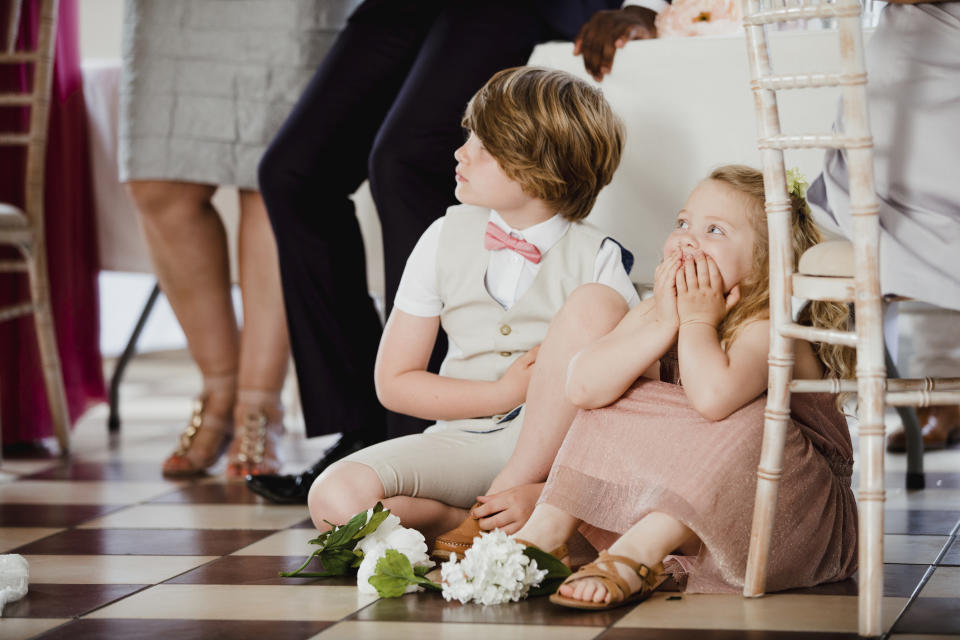 Two young children sitting on the floor next to a table