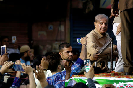 FILE PHOTO: Supporters of Shahbaz Sharif, brother of ex-prime minister Nawaz Sharif, and leader of Pakistan Muslim League - Nawaz (PML-N) use their mobile phones to take photos of him during a campaign rally ahead of general elections in the Lyari neighborhood in Karachi, Pakistan June 26, 2018. REUTERS/Akhtar Soomro