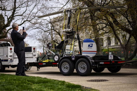 A man takes pictures of a gyro copter that was flown onto the grounds of the U.S. Capitol as it is towed from the west front lawn in Washington April 15, 2015. REUTERS/James Lawler Duggan