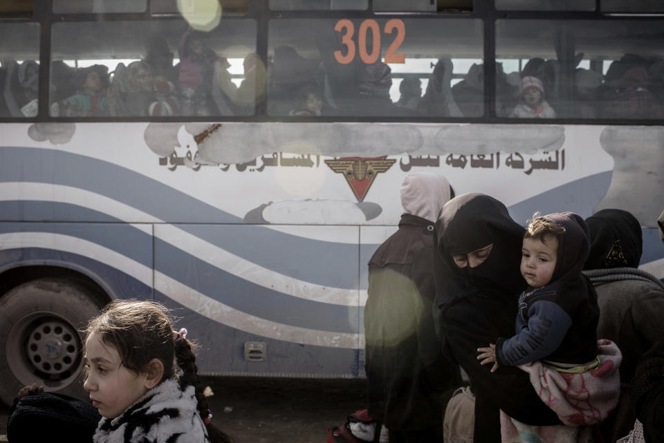 Iraqis displaced from Mosul load onto buses for transportation to IDP camps, in near Bartella, Iraq on Thursday, Dec. 29, 2016. Breaking a two-week lull in fighting, Iraqi troops backed by the U.S.-led coalition's airstrikes and artillery pushed deeper into eastern Mosul on Thursday in a multi-pronged assault against Islamic State militants in the city. (AP Photo/Cengiz Yar)