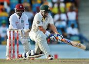 Australian batsman Michael Hussey plays a shot off West Indies bowler Narsingh Deonarine as wicketkeeper Carlton Baugh looks on during the final day of the first-of-three Test matches between Australia and West Indies at the Kensington Oval stadium in Bridgetown on April 11, 2012. Australia is chasing a target of 192 runs to win the match. AFP PHOTO/Jewel Samad (Photo credit should read JEWEL SAMAD/AFP/Getty Images)