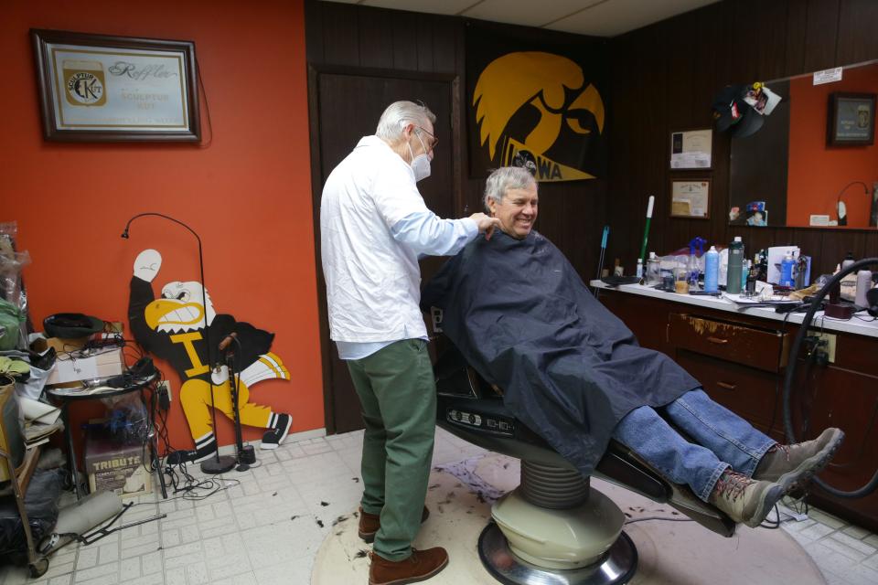 Tom Bergman, a longtime Iowa City barber, cuts Bruce Temple's hair Wednesday, Dec. 13, 2023.