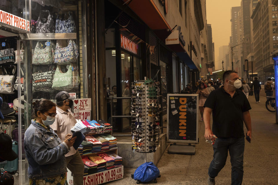 A person sells face masks outside a souvenir store in New York on Wednesday, June. 7, 2023. Smoke from Canadian wildfires drifted into the U.S. East Coast and Midwest on Wednesday, covering cities in both nations in an unhealthy haze, holding up flights at major airports and prompting people to fish out pandemic-era face masks. (AP Photo/Yuki Iwamura)