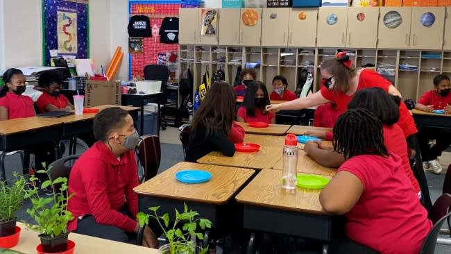 Cossey passes out samples from the garden to her students. (Photo credit: Michelle Alfini/ Spectrum News 1)