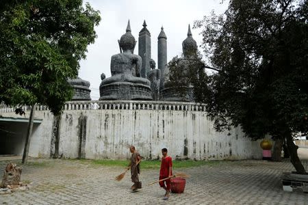 A Buddhist monk and a patient sweep the yard of the rehabilitation and detox area at Wat Thamkrabok monastery in Saraburi province, Thailand, February 3, 2017. REUTERS/Jorge Silva