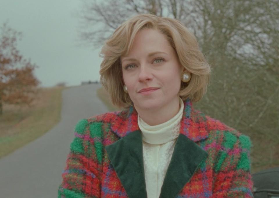 Kristen Stewart as Princess Diana stands along a quiet road in "Spencer"