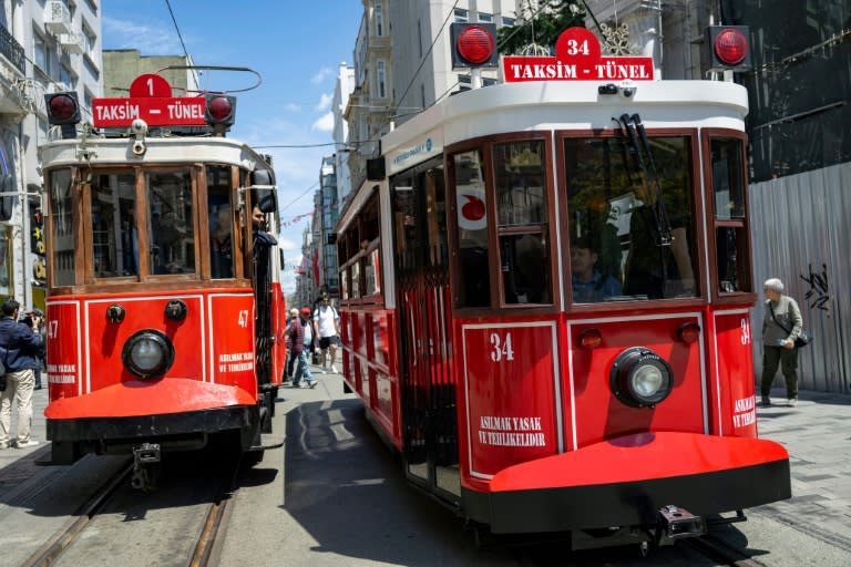 L'emblématique tramway rouge et blanc d'Istanbul, en version classique à gauche, en version moderne, avec batteries électriques à droite, en Turquie le 15 mai 2024 (Yasin AKGUL)