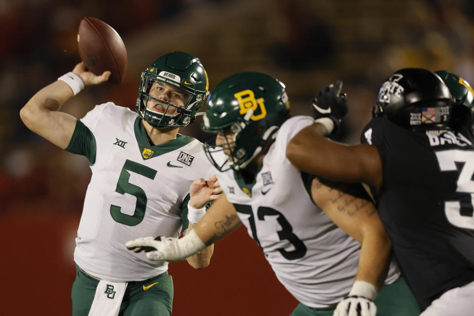 FILE - In this Nov. 7, 2020, file photo, Baylor quarterback Charlie Brewer throws a pass as offensive lineman Jake Burton, center, holds back Iowa State defensive end JaQuan Bailey during the second half of an NCAA college football game in Ames, Iowa. Brewer is set for his 25th consecutive start as Baylor’s quarterback, and 37th overall, when Baylor plays Kansas State this week. (AP Photo/Matthew Putney, File)