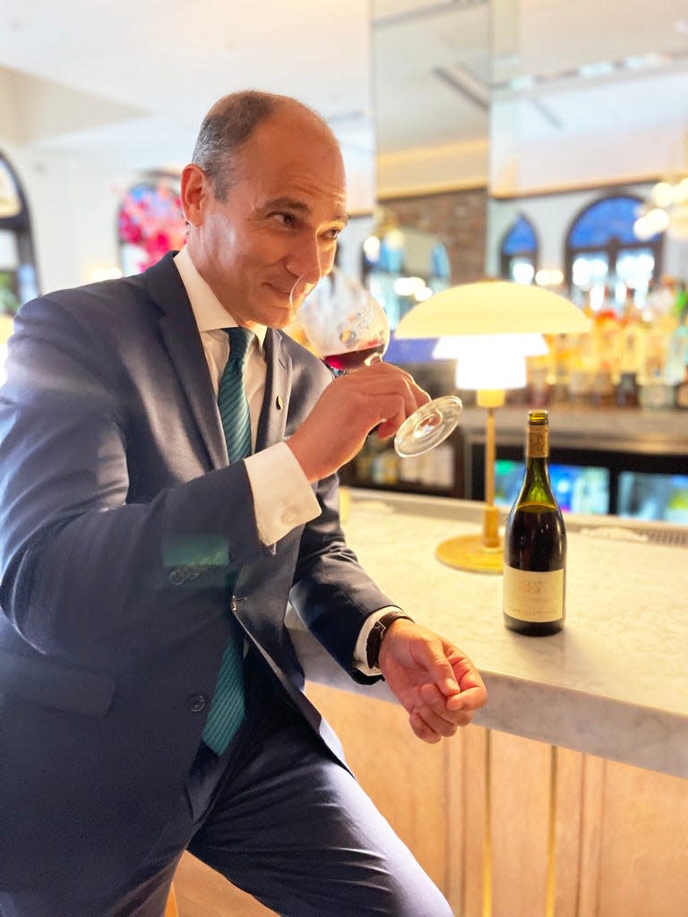Cafe L'Europe sommelier Sergio Cuadros sipping wine.