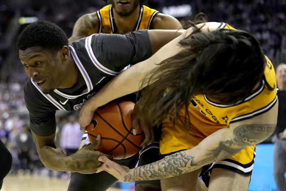 Kansas State guard Cam Carter, left, and Wichita State guard Bijan Cortes battle for a loose ball during the first half of an NCAA college basketball game Thursday, Dec. 21, 2023, in Kansas City, Mo. (AP Photo/Charlie Riedel)