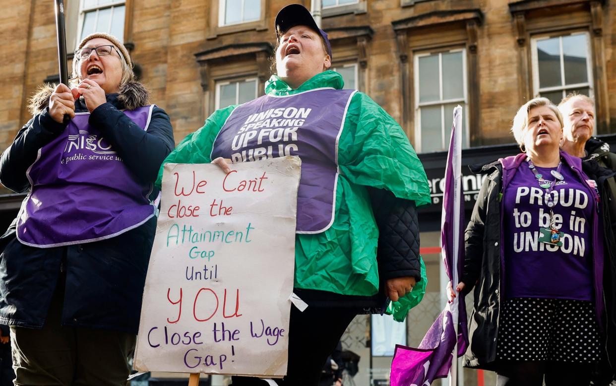 Union members wear purple tabards and appear to be singing or chanting