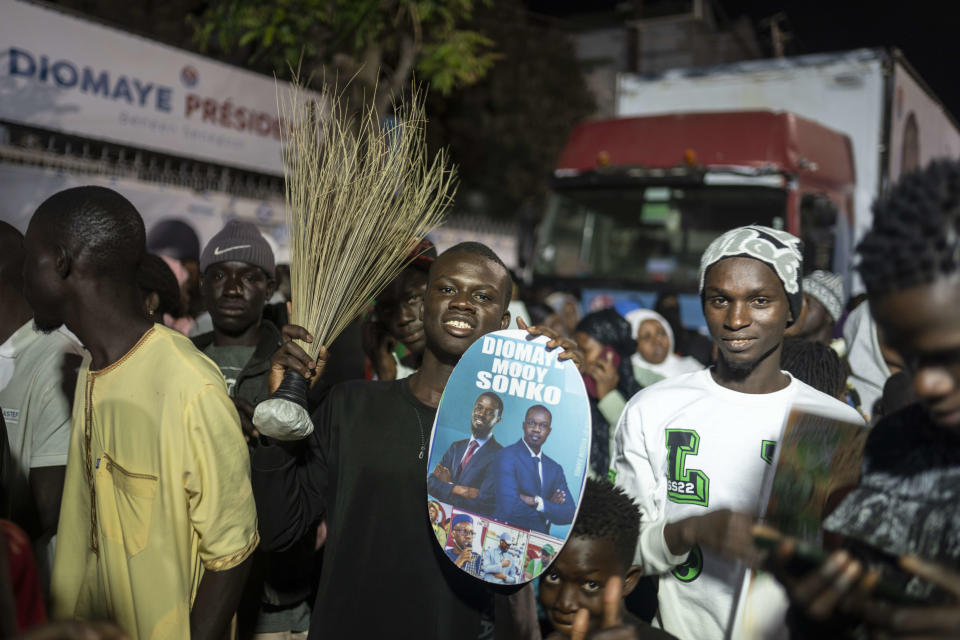 Supporters of presidential candidate Bassirou Diomaye Faye and Senegal's top opposition leader, Ousmane Sonko, gather outside their campaign headquarters as they await the results of the presidential election, in Dakar, Senegal, Sunday, March 24, 2024. (AP Photo/Mosa'ab Elshamy)
