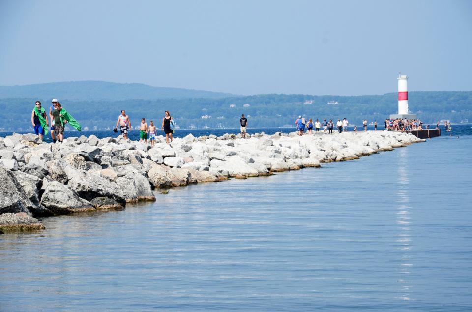 People walk along the break water in Petoskey in August 2018.