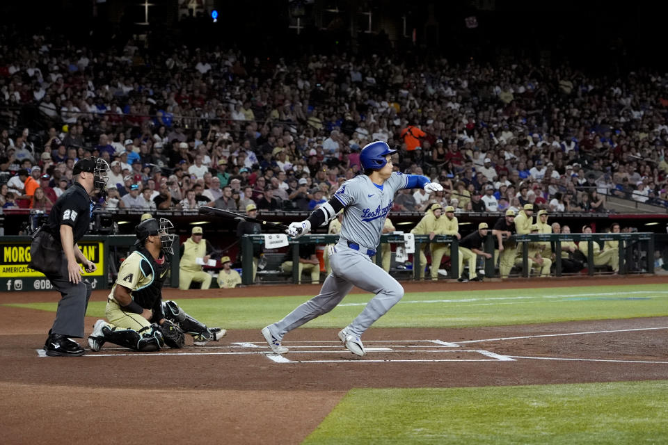 Los Angeles Dodgers' Shohei Ohtani follows through on a base hit against the Arizona Diamondbacks during the first inning of an MLB baseball game, Tuesday, April 30, 2024, in Phoenix. (AP Photo/Matt York)