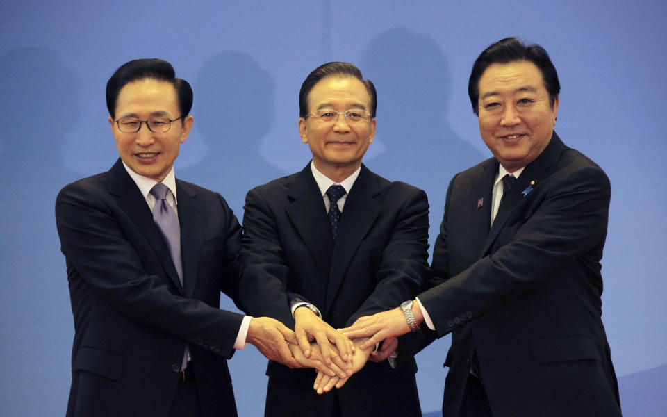 South Korea's President Lee Myung-bak, left, China's Premier Wen Jiabao, center, and Japan's Prime Minister Yoshihiko Noda hold their hands together as they pose for photographs ahead of the fifth trilateral summit among the three nations in Beijing, Sunday, May 13, 2012. (AP Photo/Petar Kujundzic, Pool)