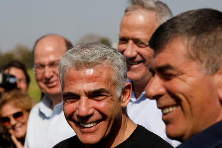 FILE PHOTO: Benny Gantz, head of Blue and White party, stands next to fellow party candidates during a visit to a kibbutz in Israel outside the northern Gaza Strip, March 13, 2019. REUTERS/Amir Cohen/File Photo