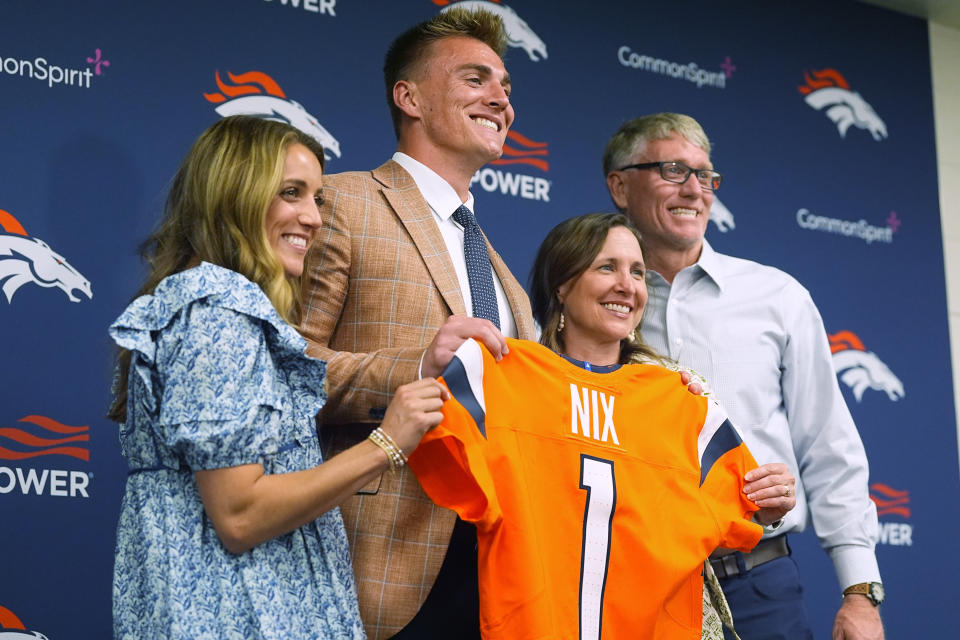 Denver Broncos draft pick quarterback Bo Nix, second from left; his wife, Izzy, left; and parents, Krista and Patrick Nix, pose for photographs after a news conference Friday, April 26, 2024, at in Centennial, Colo. (AP Photo/David Zalubowski)