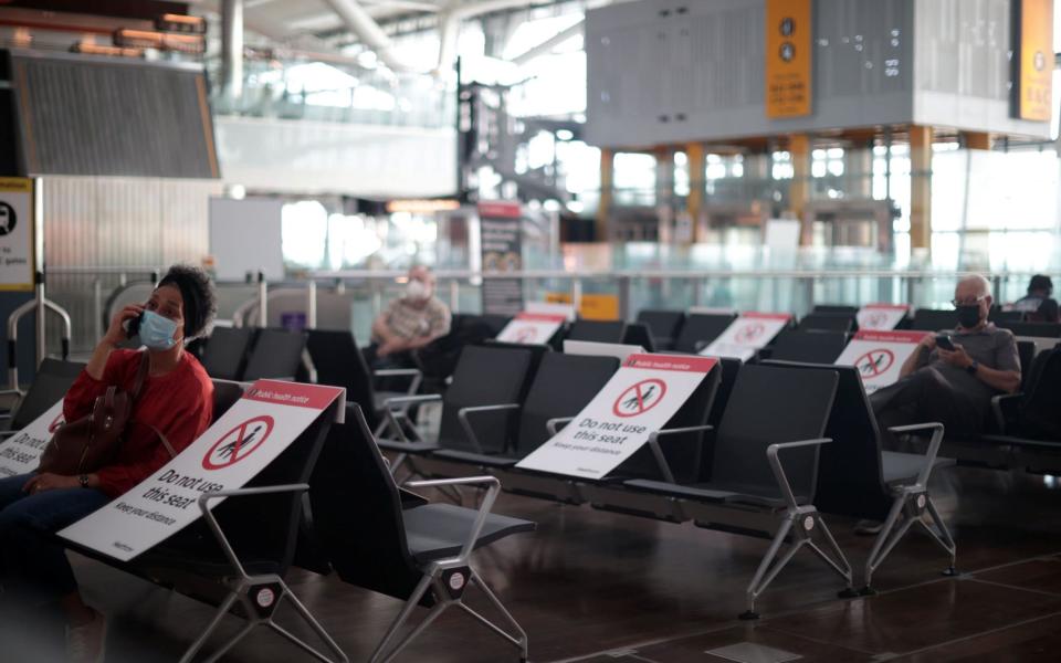 Passengers wait at the Terminal 5 departures area at Heathrow Airport in London amid coronavirus restrictions - HANNAH MCKAY/REUTERS